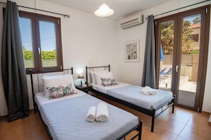 Ein Hotelzimmer mit zwei Betten, einem Balkon und Blickrichtung nach außen.