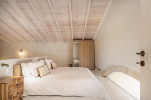 Een slaapkamer met een groot bed, een houten nachtkastje en een inbouwkleerkast.