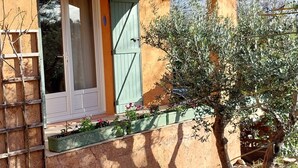 A rustic building with a tiled roof, a wooden door, and a small garden area with a tree and plants. - Bed and breakfast, Besse sur Issole, Var. Ideal for a quiet, sunny stay (Besse-sur-Issole)