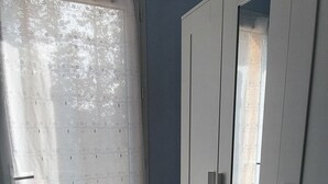 A room with a window covered by a patterned curtain, a wardrobe with a mirror, and tiled flooring. - Bed and breakfast, Besse sur Issole, Var. Ideal for a quiet, sunny stay (Besse-sur-Issole)