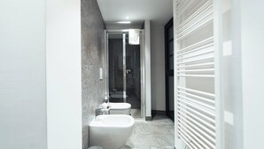 Une salle de bain moderne équipée de toilettes, d’un bidet et d’une douche.