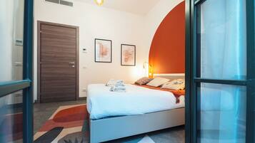 Quarto moderno com cama, porta e luminária fixada na parede.