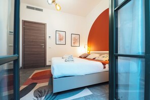 A modern bedroom with a bed, a door, and a wall-mounted light fixture. - Ciclamino - Modern apartment with private parking. Lake view (Bellano)