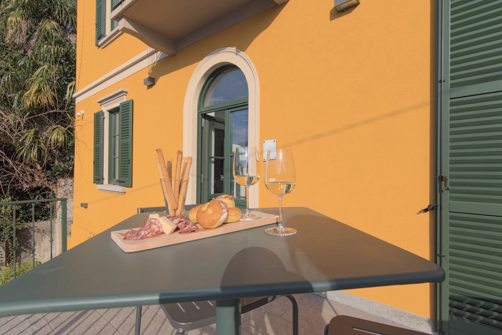 Ein Tisch mit Speisen und Wein auf einem Balkon.