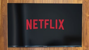 Una TV a schermo piatto montata su un muro di legno con il logo Netflix.