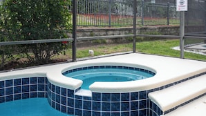 Ein Whirlpool mit blau gefliestem Innenraum und weißen Stufen zum Ein- und Ausstieg.