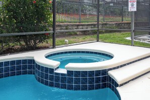 A hot tub with a blue-tiled interior and white steps leading into it. - Amazing Disney Dream Getaway in Windsor Palms Resort! (Kissimmee)