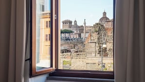 A window view of ancient ruins and classical architecture. - Large 6-Bed Stay near the Colosseum (Rome)