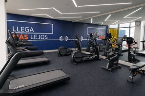 Ein Fitnessstudio mit Laufbändern, Crosstrainern und Ergometer.