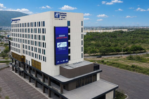 A modern hotel with a prominent 'Gran Apertura' sign, multiple floors, and a parking lot. - Holiday Inn Express And Suites Monterrey Sendero (Escobedo)