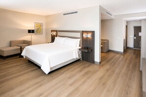 A modern hotel room with a large bed, bedside tables, a sofa, and a lamp. - Holiday Inn Express And Suites Monterrey Sendero (Escobedo)