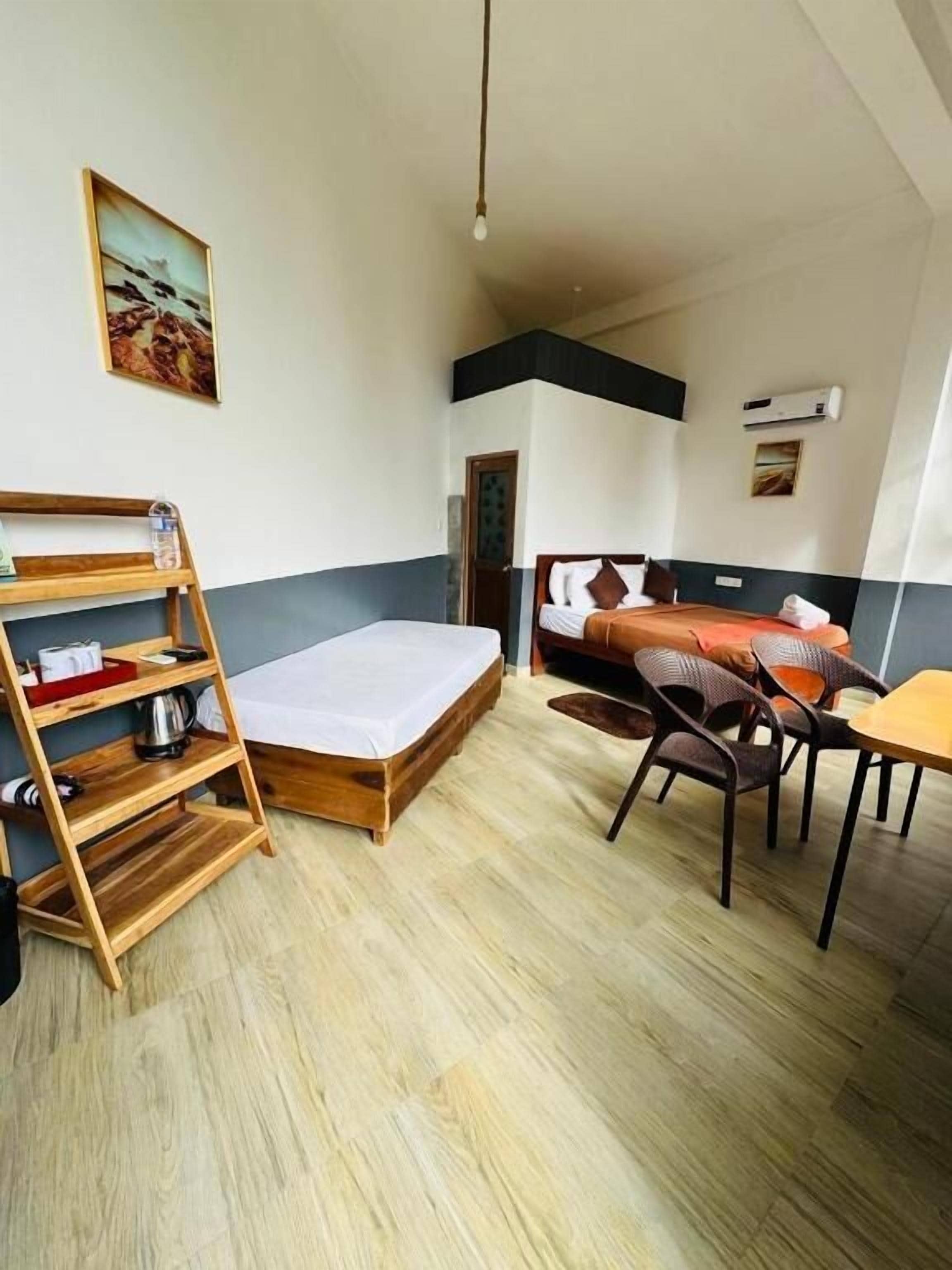 Una habitación con cama, escritorio, silla, estante de madera y un cuadro en la pared.