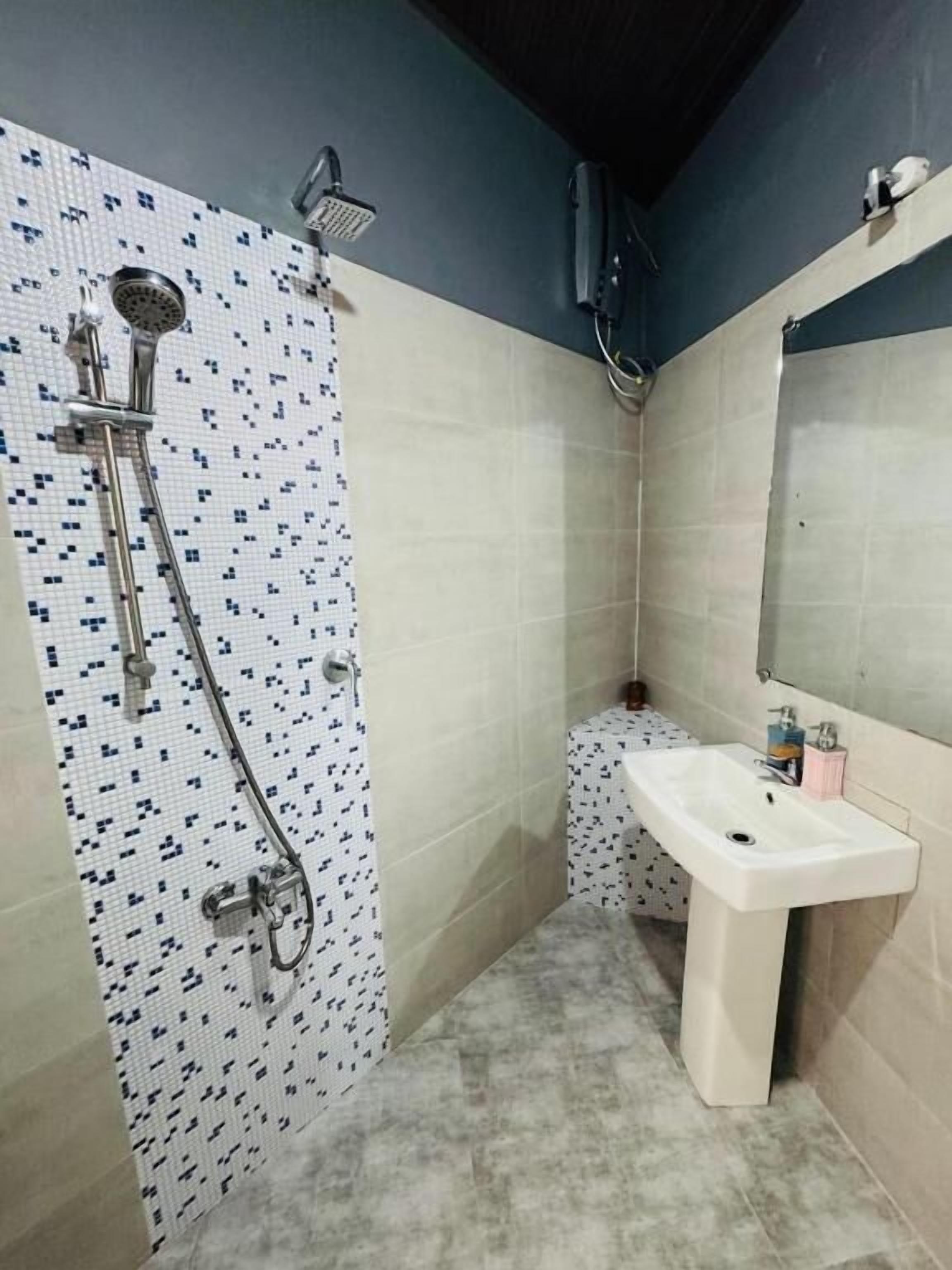 Ein Badezimmer mit Dusche, Waschbecken und Spiegel.