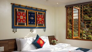 A neatly made bed with white linens and decorative pillows, a wall hanging above, and a window with a view of greenery. - Lee Homestay SaPa (Sa Pa)