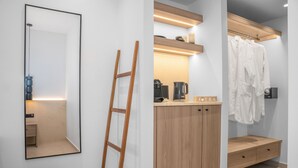 Un bagno moderno con un mobile bagno in legno, uno specchio, un portasciugamani e un lampadario.