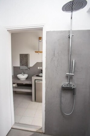 Un baño moderno con ducha, lavamanos y espejo.