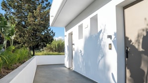 Un edificio moderno con facciata bianca e pulita, tetto piano e ingresso delimitato da cancello.