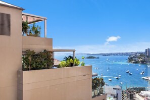 A modern building with a balcony overlooking a marina with boats. - Harbourview Studio – Iconic Sydney Views from Potts Point (Potts Point)