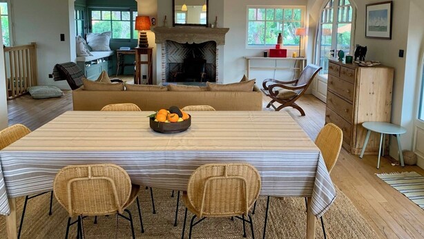 A dining area with a striped tablecloth, wicker chairs, and a fruit bowl. - A0003 Newly renovated villa with pool and bay view steps from the beach (Lège-Cap-Ferret)