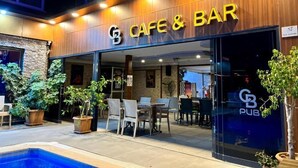A cafe and bar with outdoor seating and a pool. - Cemal Bey Hotel (Alanya)