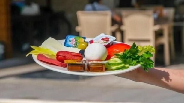 A tray with food items and drinks being held over a pool. - Cemal Bey Hotel (Alanya)