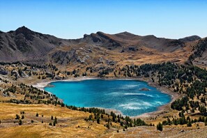 A mountainous landscape with a lake surrounded by forested areas and rocky terrain. - Les Chalets du Verdon 2p5n (Allos)