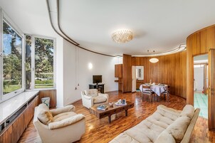 Un soggiorno moderno con un divano, poltrone, un tavolino da caffè e un'area pranzo con tavolo e sedie.