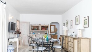 Ein Essbereich mit einem runden Tisch, Stühlen und einem Schrank.