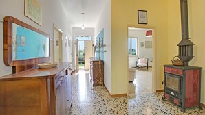 A hallway with a wooden counter, a vintage stove, and a door leading to another room. - Cozy Counrtry House Btn Florence Arezzo4 (Terranuova Bracciolini)