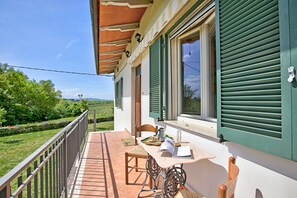 A balcony with a table, chairs, and a view of the countryside. - Cozy Counrtry House Btn Florence Arezzo4 (Terranuova Bracciolini)