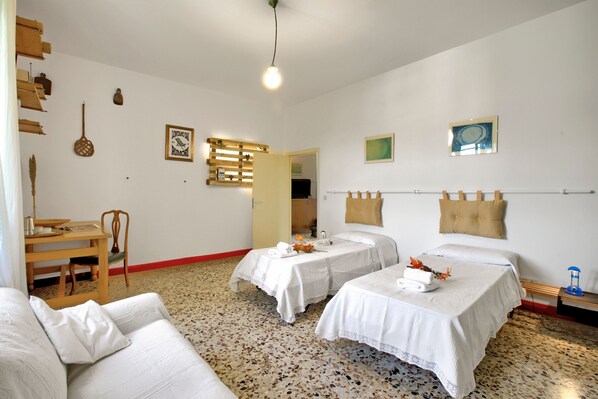 A hotel room with two beds, a sofa, a desk, and a chair. - Cozy Counrtry House Btn Florence Arezzo4 (Terranuova Bracciolini)