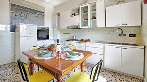 A kitchen with white cabinets, a wooden dining table, and chairs. There is a refrigerator, oven, and sink. - Cozy Counrtry House Btn Florence Arezzo4 (Terranuova Bracciolini)