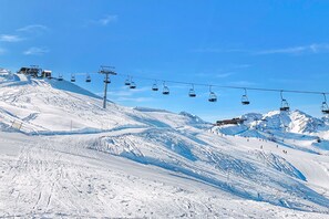 A ski lift with chairs moving up and down a snowy mountain slope. - Appartamento La Selva Incantata (Sauze d'Oulx)