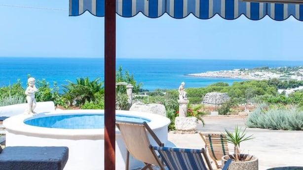 A pool area with a view of the sea, outdoor seating, and a pergola. - Felloniche Apartment Sea View (Castrignano del Capo)