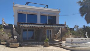A two-story building with a stone facade, large windows, and a central entrance with steps. - Felloniche Apartment Sea View (Castrignano del Capo)