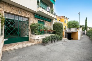 A building with a green gate, a balcony, and potted plants. - Seaside Binario Blu 500 M Dal Mare (Alassio)