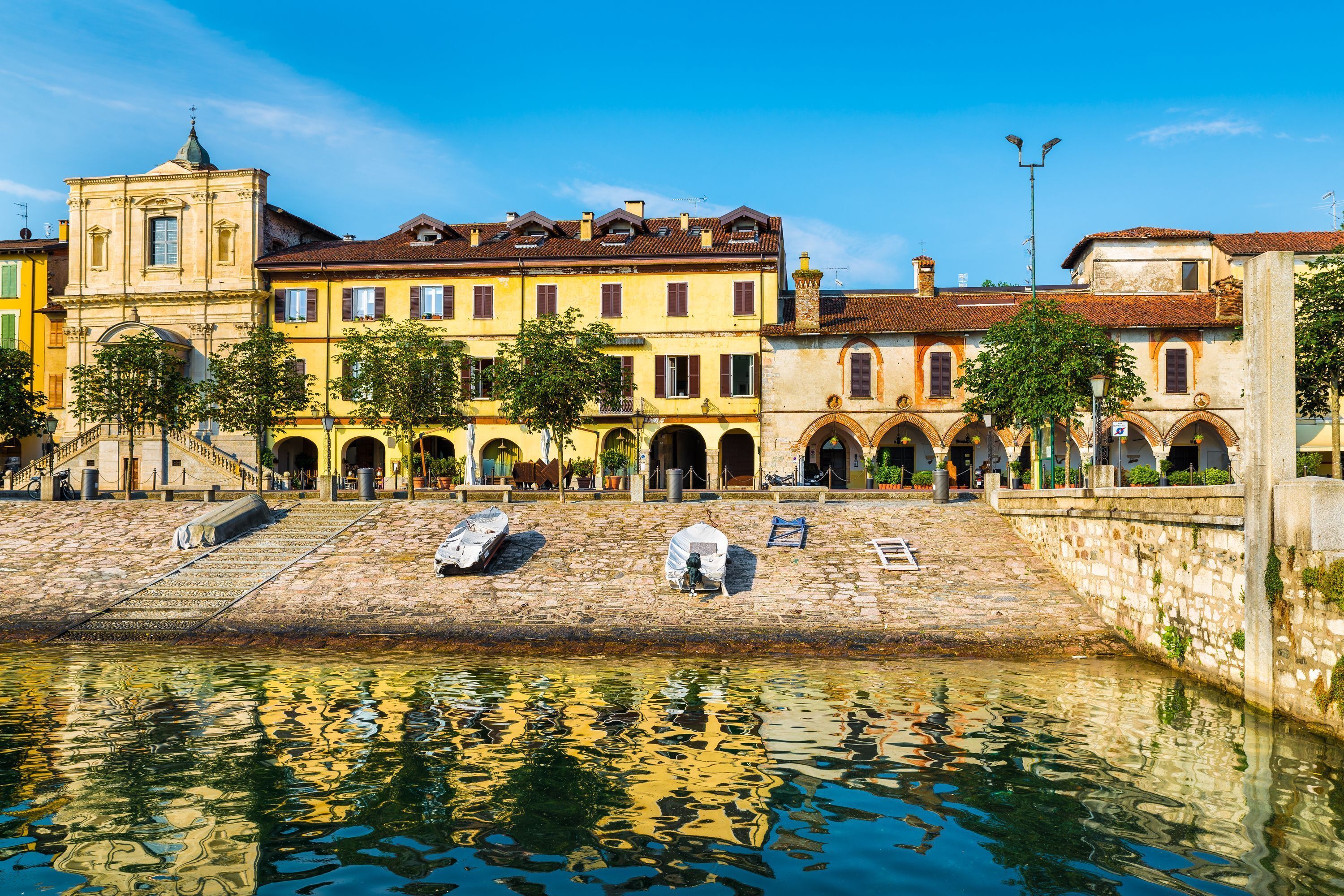 A historic building with multiple arches and a stone staircase leading to a water body.
