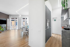 Eine moderne Küche mit Einbauofen und Essbereich mit Tisch und Stühlen.