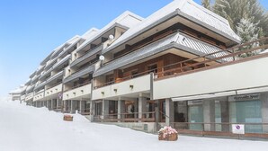 A multi-story hotel with balconies and a ski slope in the background. - Prestige Eleven In The Center Of Town (Sestriere)