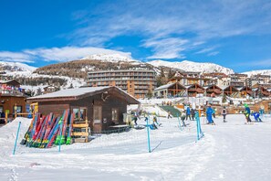 Une station de ski comprenant plusieurs bâtiments, notamment un chalet en bois et un hôtel à plusieurs étages.