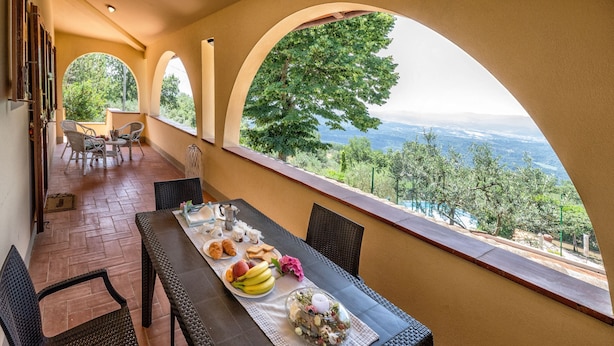 Un comedor con una mesa dispuesta para dos personas, con vistas a un paisaje pintoresco.