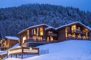 A wooden lodge with multiple balconies and a sign indicating it is a ski resort. - R Sidence Les Portes de Meg ve C58e (Praz-sur-Arly)