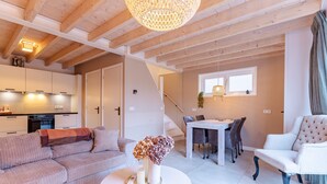 A modern living space with a sofa, a dining table, and a chair. - Holiday Home - Schoolstraat 6a Vrouwenpolder (Vrouwenpolder)