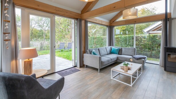 A modern living room with a sofa, coffee table, and a fireplace. - Zonnedorp 21 Beach Villa Joya Renesse Luxury Beach Villa With Sauna (Renesse)