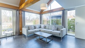 Una sala de estar moderna con un sofá modular, una mesa de centro y ventanas amplias.