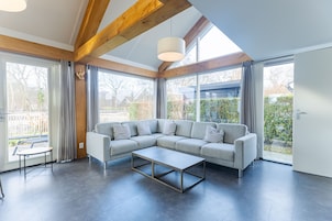 A modern living room with a sectional sofa, a coffee table, and large windows.