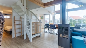 A spacious living area with a staircase, a fireplace, and a view of the outside. - Zonnedorp 1 Solskin Renesse Beach Holiday in Modern Holiday Home (Renesse)