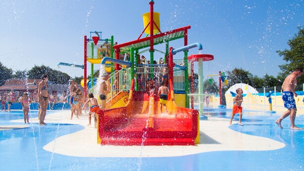 A water park with a central water play structure surrounded by a pool. - Duinhoeve Duinlodges 4pers Huisdiervriendelijk (Burgh-Haamstede)