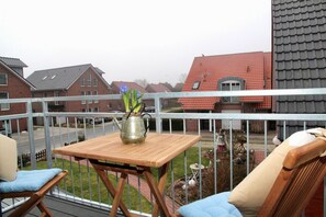 A balcony with a table, chairs, and a metal railing. - Deichkrone - New Deichkrone vacation apartment with harbor view, balcony & (Krummhörn)