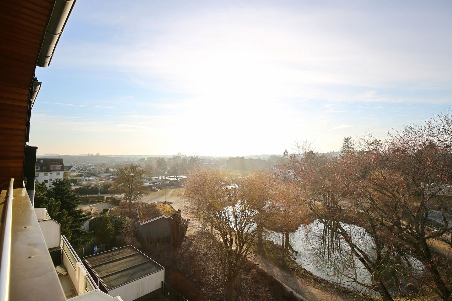 A residential area with houses, a body of water, and trees.
